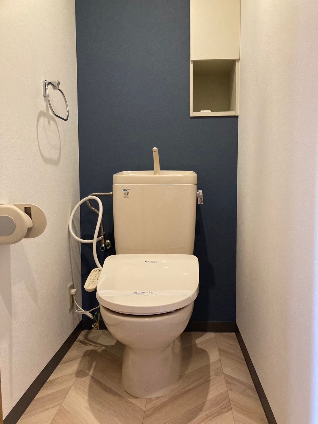 ネイビーと白い石目調の壁紙で高いデザイン性を持ち合わせたトイレ空間