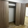 Panasonic VERITISの折れ戸建具で仕上げたクローゼットの施工後写真。ナチュラルな木目調デザインで室内と調和した収納空間。