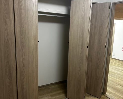 Panasonic VERITISの折れ戸建具で仕上げたクローゼットの施工後写真。ナチュラルな木目調デザインで室内と調和した収納空間。