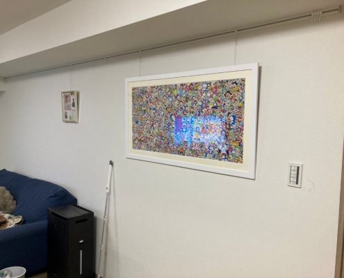 品川区T様邸のLDK施工後｜白いクロス（サンゲツSP9701）とピクチャーレールを取り付けた壁面。大型アート作品が飾られ、明るく清潔感のある空間にリフォーム完了。
