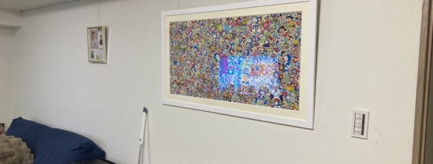 品川区T様邸のLDK施工後｜白いクロス（サンゲツSP9701）とピクチャーレールを取り付けた壁面。大型アート作品が飾られ、明るく清潔感のある空間にリフォーム完了。
