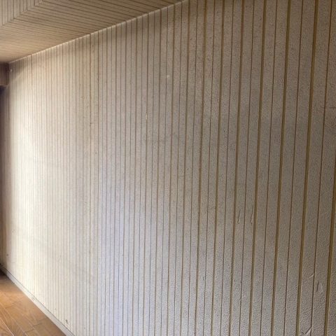 品川区T様邸のLDK施工前｜黄ばみや汚れが目立つ古い縦縞模様の壁紙が貼られた状態。クロスの劣化が進み、暗く閉塞感のある室内。