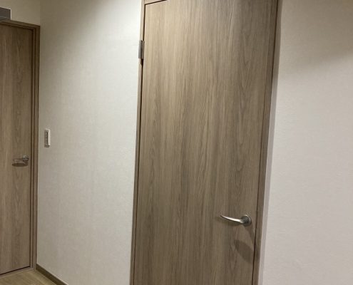 木目調ドアと白いクロスで統一された洋室の施工後の様子｜マンション内装リフォーム