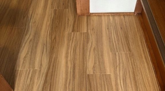 補修後にナチュラルな木目調フロアータイルで仕上げた玄関付近の床