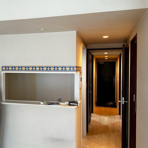 東京都大田区O様邸マンションのLDKリフォーム後、キッチン上壁を撤去し新しい白いカウンターとダウンライトを設置した明るく開放的な空間