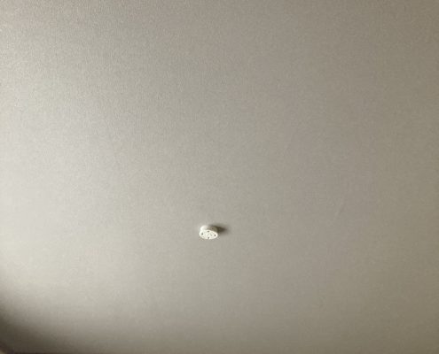 東京都大田区Y様邸の天井クロス張り替え後。サンゲツSP9795を使用し、中央にシーリングコンセントを新設した洋室仕様の天井。