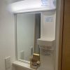 東京都大田区の賃貸マンション原状回復工事で交換した新しい洗面化粧台。LED照明付きミラーと白いクロスで明るく清潔感のある仕上がり