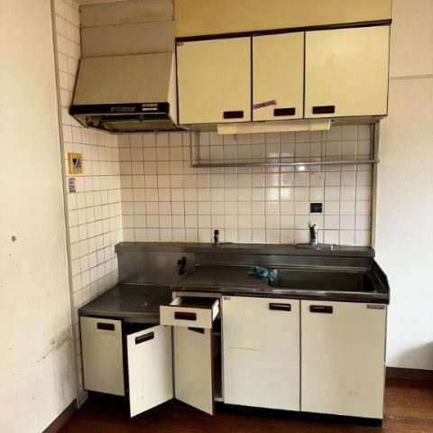 施工前の古いブロックキッチンの様子。経年劣化で扉の変色やサビ、油汚れが目立ち、レンジフードやタイル壁も劣化していた東京都大田区の賃貸マンションの原状回復前の状態。