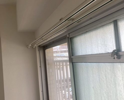 丁寧に塗装された窓枠と水平に取り付けられたカーテンレールの仕上がり。入居前の原状回復工事で明るさと美観が向上した様子。