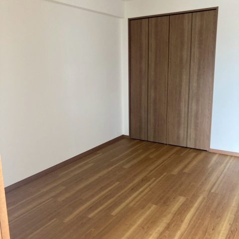 東京都大田区 I様邸｜サンゲツ SP-9712 の白クロスと木目フローリングで全面洋室化した施工後写真。明るく開放的な室内とクローゼットに改修された収納が映る仕上がり。