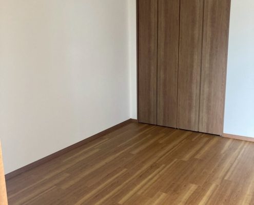 東京都大田区 I様邸｜サンゲツ SP-9712 の白クロスと木目フローリングで全面洋室化した施工後写真。明るく開放的な室内とクローゼットに改修された収納が映る仕上がり。