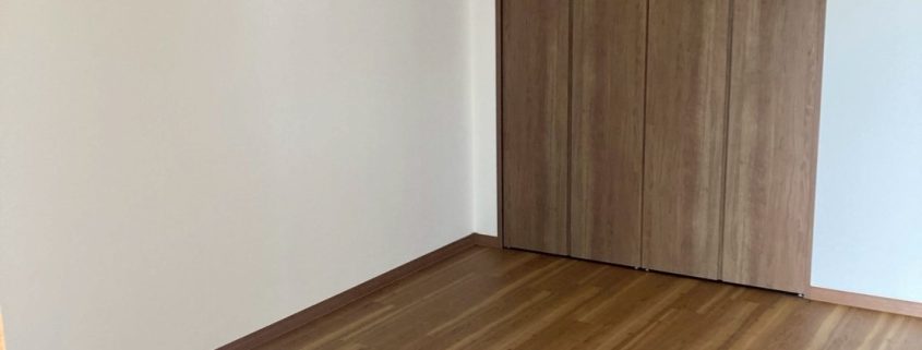 東京都大田区 I様邸｜サンゲツ SP-9712 の白クロスと木目フローリングで全面洋室化した施工後写真。明るく開放的な室内とクローゼットに改修された収納が映る仕上がり。