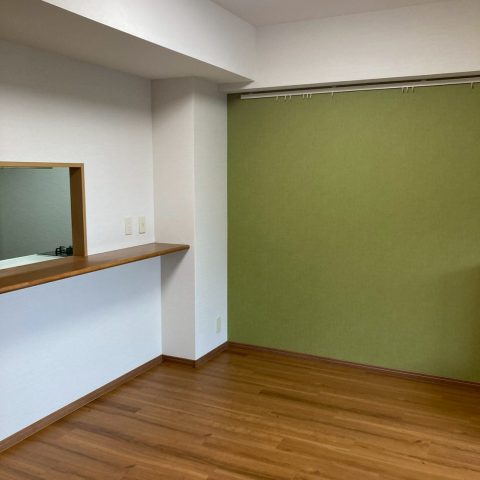 アクセントクロスとヘリンボーン調フローリングを採用したキッチン内装リフォーム施工後の様子。落ち着きと温かみのある空間に仕上がったマンションのキッチン。