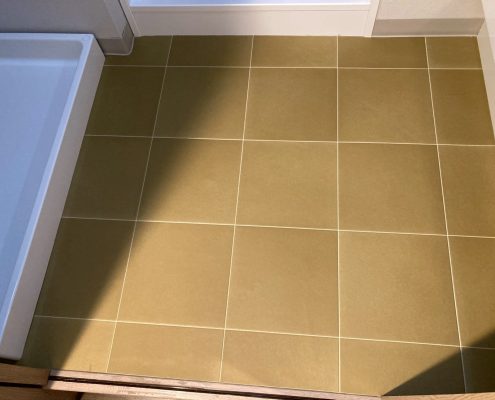 洗面所の床張り替え後の様子。サンゲツHM17039のタイル調フロアで明るく清潔感のある仕上がり（東京都大田区マンション）