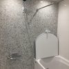 マンション浴室リフォーム後のユニットバス内部。明るい石目調パネルと使いやすいシャワー位置の施工例