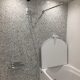 マンション浴室リフォーム後のユニットバス内部。明るい石目調パネルと使いやすいシャワー位置の施工例