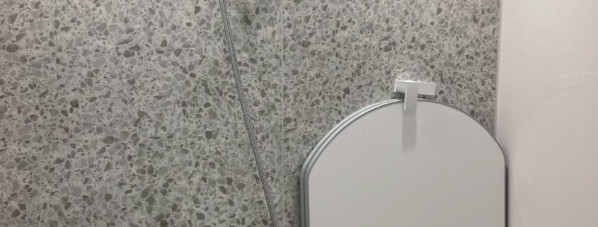 マンション浴室リフォーム後のユニットバス内部。明るい石目調パネルと使いやすいシャワー位置の施工例