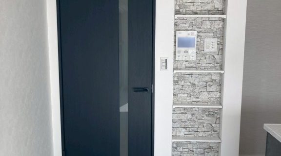 東京都大田区S様邸 リビング壁面リフォーム施工後 石目調アクセントクロスと縦長ニッチ造作