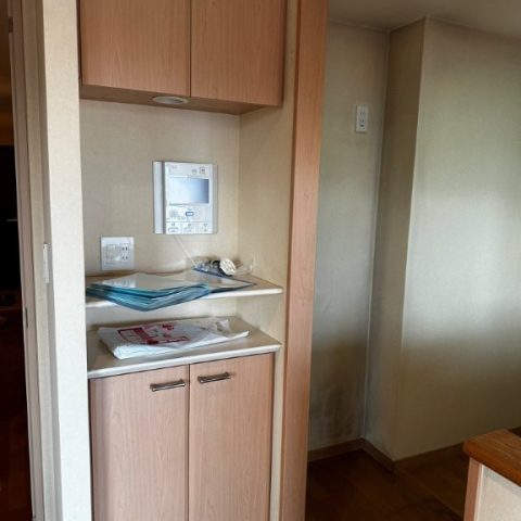 東京都大田区S様邸 マンションリビング施工前 木目カウンター収納と吊戸棚のある壁面